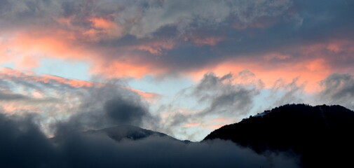 Sunset after a rainy day with grey and red clouds over the Val d'Ultimo near Merano in South Tyrol	 - obrazy, fototapety, plakaty