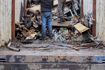 scales with metal at the reception of recyclable materials for recycling and people helping to load them into a container