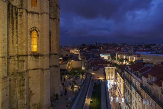 Old ruin of Convento do Carmo during nighttime with view over the city centre of portuguese capital and Parca Dom Pedro IV, Lisbon, Portugal