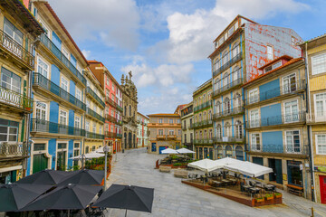 Shops and sidewalk cafes at the colorful Largo São Domingos square with the Porto Misericórdia...