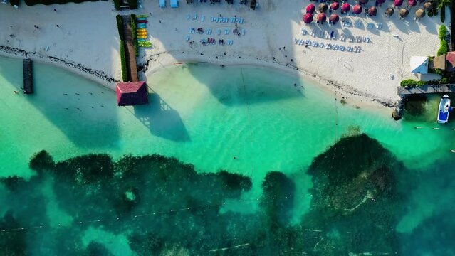 Vista aerea de la playa en un hotel con camastros en el mar turquesa del caribe Mexicano en canc&uacute;n