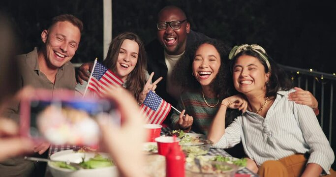 Happy people, friends and photography at night for party, dinner or independence day. Group smile in diversity for photograph, picture or memory with American flag by dining table in late evening