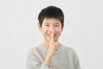 内緒のポーズをする男の子　白背景