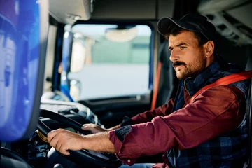 Deurstickers Professional truck driver driving on road. © Drazen