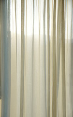 Beige voile curtains background with sunlight shining through