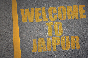 asphalt road with text welcome to Jaipur near yellow line.