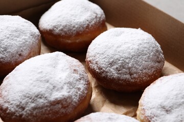 Fototapeta na wymiar Delicious buns with powdered sugar in box, closeup