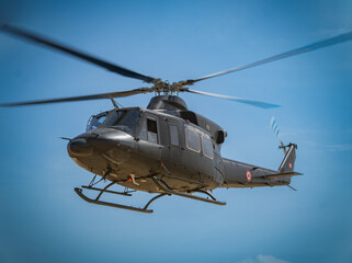 military helicopter in flight supporting ground personnel 