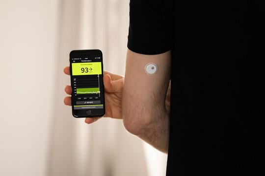 DRESDEN, GERMANY - 21. January 2024: FreeStyle Libre 3 sensor and app on the smartphone. The CGM device is measuring the glucose in the tissue and sending data to the digital health application.