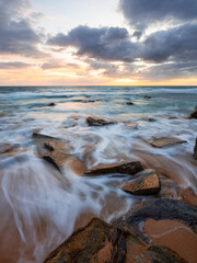 Rocky beach shore with flowing water.