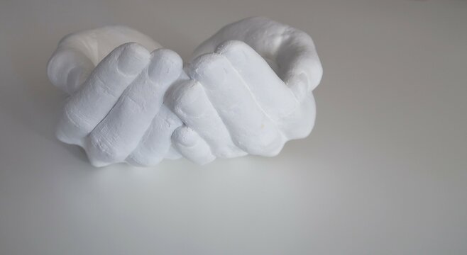 Gipsum folded hands on white background