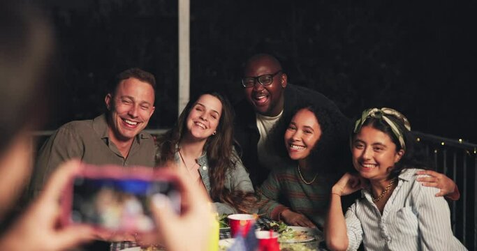 Happy people, friends and photography at night for dining, event or outdoor get together on bench. Group smile in diversity for photograph, picture or memory by dinner table in late evening outside