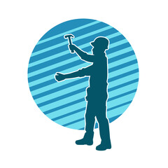 Obraz premium Silhouette of a worker carrying hammer tool. Silhouette of a worker in action pose using hammer tool.