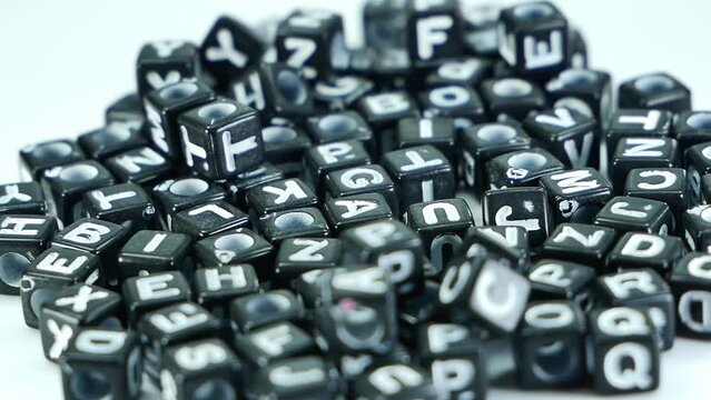 Black alphablocks with english letters slow movement on a white background.
