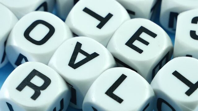 Alphablocks , white dice printed with english letters slow movement on a white background.