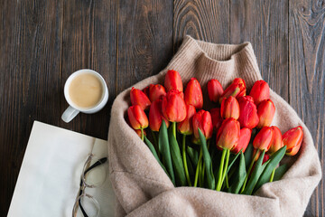 Fresh orange tulips with open book or diary on wooden background. Springtime