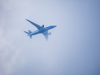 Fototapeta na wymiar 雲を避けて飛ぶ旅客機