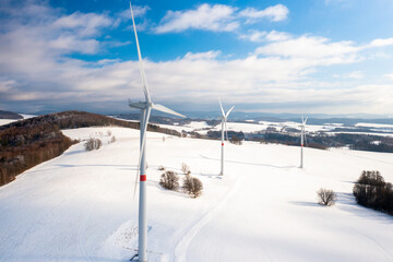 Aerial view of wind turbines for production of green energy in winter landscape