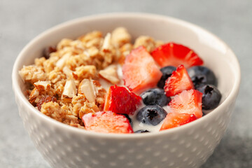 Oatmeal granola with yogurt, berries and nuts in a bowl on the table. Healthy breakfast