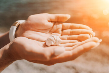 Beach vacation snapshot: A woman in a swimsuit holding a pebble in her hands, enjoying the serenity...