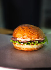Fresh tasty burger on dark background. Soft focus. Vertical photo. High quality photo
