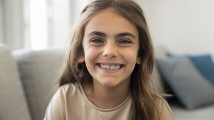 Happy Latin preteen child girl looking at camera, smiling, laughing, talking on video conference...