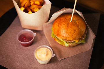 Top view of cheeseburger with chicken and fries with sauce. High quality photo. Selective focus. Horizontal Dark photo