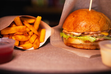 cheeseburger with chicken and fries with sauce. High quality photo. Selective focus. Horizontal Dark photo
