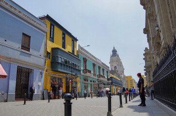 Colonial Latin American architecture downtown house building facades with busy traffic street, police and people tourists in old town Lima, Peru with every day big city life scenery