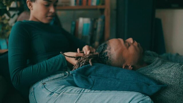 Relax, home and black couple braiding hair for bonding, happy relationship and embrace on floor. Dating, love and African man and woman in conversation, talking and chat for romance in living room