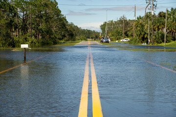 Flooded empty street after hurricane rainfall in Florida residential area. Consequences of natural...