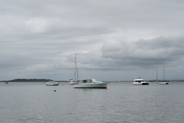 Boats anchored in Moreton Bay between Coochiemudlo Island and Victoria Point, on an overcast day. Queensland, Australia.