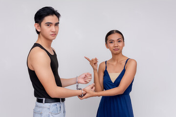 A woman points to a man in handcuffs, Concept of forcing a young man into a coerced relationship.