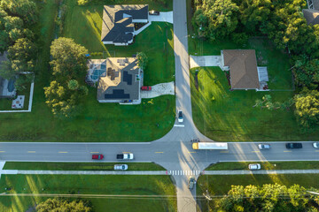 Top view of standard american yellow school bus picking up kids at rural town street stop for their...