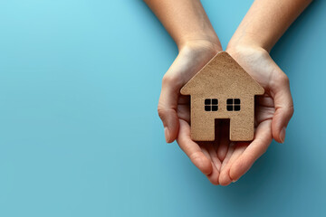 Hands holding house on blue background , New home, family home, Real estate agency concept - obrazy, fototapety, plakaty