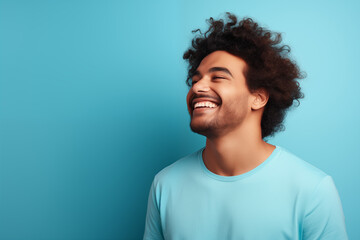 The young boy laughed with a natural smile on his face. blue background. Y001