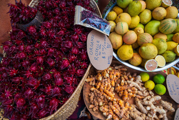 Three baskets of fresh fruit and produce await sale at a Farmers Market on Kauai