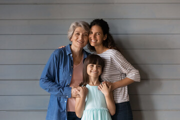 The dearest people. Happy small school age girl daughter her young mom and senior retired grandma...