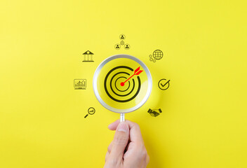 Business growth and marketing target concepts. Holding a magnifying glass with aim bullseye icon...