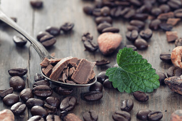 Broken dark chocolate and coffee beans on a table