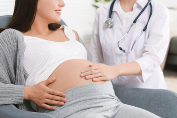 Doctor examining pregnant woman in clinic, closeup