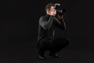 Professional photographer taking picture on black background