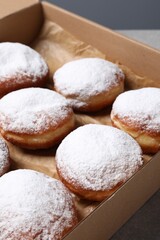 Fototapeta na wymiar Delicious buns with powdered sugar on table, closeup
