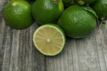 Fresh wet limes on wooden table, closeup