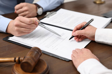 Lawyers working with documents at wooden table, closeup