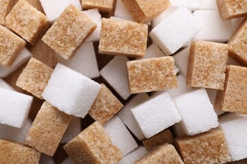 Brown and white sugar cubes as background, top view