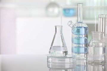 Laboratory analysis. Different glassware with liquid on white table indoors. Space for text