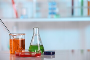 Laboratory analysis. Different glassware with liquids on white table indoors. Space for text