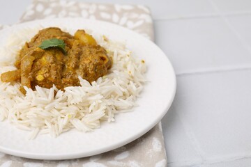 Delicious chicken curry with rice on white tiled table, closeup