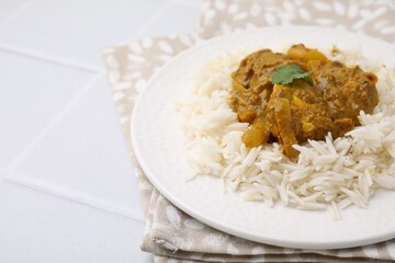 Delicious chicken curry with rice on white tiled table, closeup